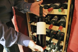 Symbolic image: Sommelier presents a bottle of red wine