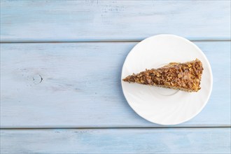 Walnut and hazelnut cake with caramel cream on blue wooden background. top view, flat lay, copy