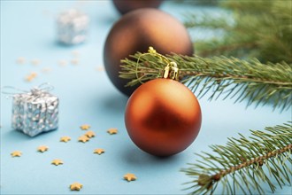 Christmas or New Year composition. Decorations, bronze balls, fir and spruce branches, on a blue