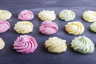 Set of colored meringues on black wooden background. top view, flat lay. geometric pattern