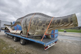 Large dinosaur figure loaded in parts on a heavy goods vehicle, Lauf an der Pegnitz, Middle