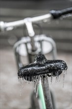 Freezing rain, icy saddle of a rental bike, after freezing rain, in the city centre of Frankfurt,