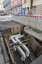 Construction site of a district heating house connection, pipes, insulated, are laid from a central