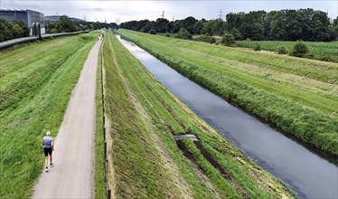 A jogger runs along the renaturalised Emscher in Gelsenkirchen, 21.07.2024. The renaturalisation,