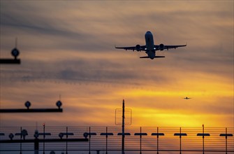 Runway lighting, approach aids, at Düsseldorf International Airport, sunset, aircraft taking off