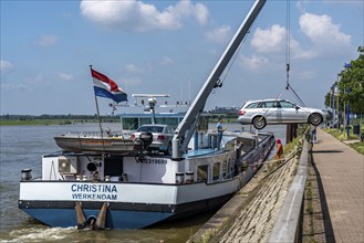 Inland waterway transport, a bargeman's vehicle is loaded from the shore onto the cargo ship with