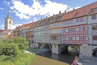 Famous Krämerbrücke and Gothic Ägidienkirche with river Gera and people sitting on the bank, idyll,