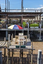 Quirky lonely seat in a restaurant on a wooden terrace, outdoor seat, gastronomy, food, dinner,