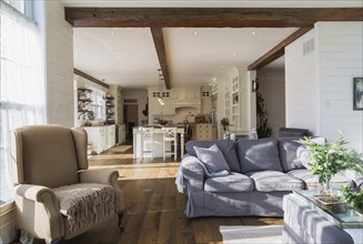 Dark grey upholstered ektorp model sofa, bergere armchair in living room with rug and stained oak