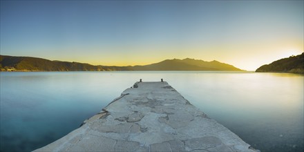 View over the jetty into a bay of the village of Enfola at sunset, evening mood, jetty, island,