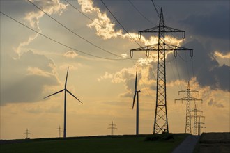 Wind farm, wind turbine, wind turbines, in front of sunset, thunderclouds, overhead power lines,