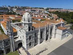 Gothic church with impressive tower and detailed façade in front of an urban landscape with