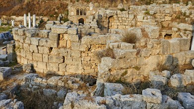 Sunlit ancient ruins with robust stone walls and some shrubs, Archaeological site, Archea