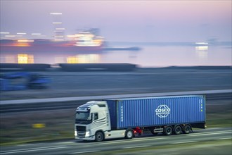 Lorry on the road to Euromax Terminal Rotterdam, ENECO wind farm on the dike around the port of