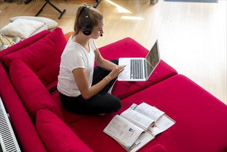 Young student learns at home, online, in conversation with other students