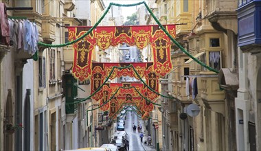 Flags decorate historic street in city centre of Valletta, Malta, Europe