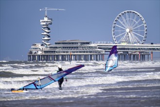 The pier and Ferris wheel at Scheveningen beach, strong swell, windsurfers, Netherlands