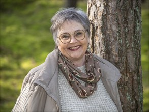 Portrait of elderly woman, 65 years old, enjoying nature in the forest in Ystad, Skåne, Sweden,