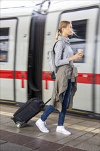 Young woman on the railway track while a train arrives