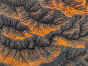 Landscape of eroded hills at Lake Issyk Kul, top-down, badlands at sunrise, aerial view, Canyon of