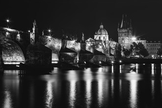 Charles Bridge (Karluv Most) on the Vltava River and Old Town Bridge Tower, at night, black and