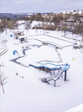 Drone view of a swimming pool in the middle of a snowy landscape, ENCW outdoor pool Calw,