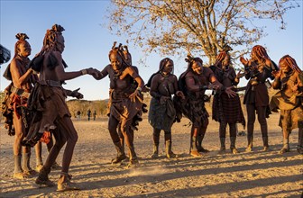 Traditional Himba woman clapping and dancing, music and dance, portraits, in the evening light,