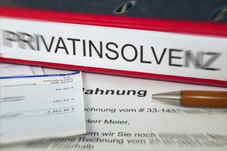 Symbolic image of personal insolvency: folder, bank statement and a reminder