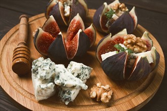 Appetizer, Figs with blue cheese, walnut, honey, on a wooden board, top view, close-up, no people