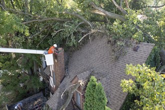 Detroit, Michigan, A worker dismantles a brick chimney after a storm with 70mph wind gusts blew