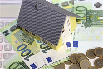 Symbolic image for property prices: Model house, euro notes and coins