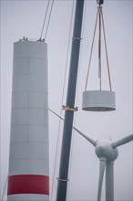 Construction of the tower of a wind power plant in a wind farm near Issum, 9 older wind turbines