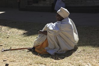 Old man, pilgrim sitting on the ground, Ethiopia, Africa