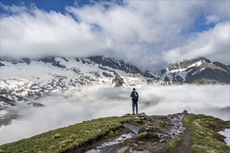 Mountaineer in front of mountain landscape with high fog in the valley, summit Hochfeiler and