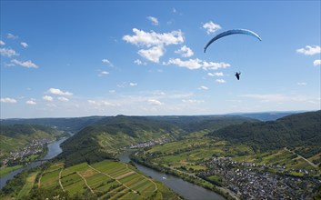 Paraglider flies high above the river with a wide view over the landscape, Paragliding, Bremm,