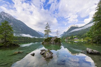 Hintersee with rocks and trees in the foreground, surrounded by mountains, cloudy sky, Ramsau,