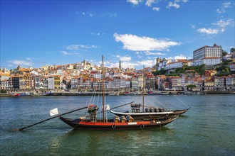 View of Porto city and Douro river with traditional boat with port wine barrels from famous tourist