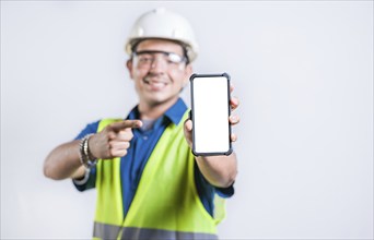 Young construction engineer showing and pointing at an advertisement on the phone screen. Happy