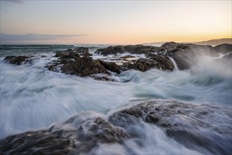 Waves washing over rocks by the sea, long exposure, coastal landscape at sunset, Playa Cocalito,