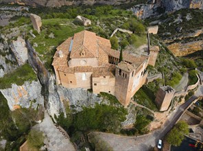 An imposing castle on a cliff with traditional tiled roofs and fortified walls, aerial view,