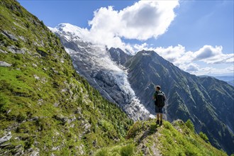 Mountaineer in front of impressive mountain landscape with glacier, view of glacier Glacier de