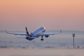 Passenger aircraft after take-off, Eurowings, in front of sunrise, fog, Baden-Württemberg, Germany,