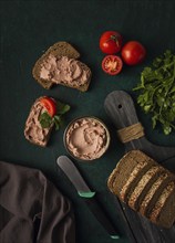 Liver meat pate spread on rye bread, breakfast, close-up, dark background. no people, selective