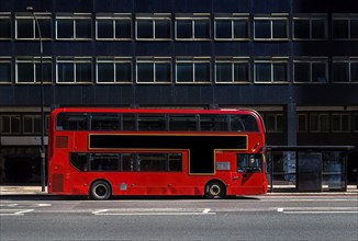 Red double-decker bus on a city street with free advertising space or advertising banner in front