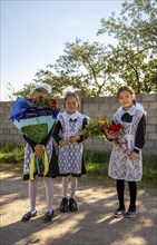 Schoolgirl with a bouquet of flowers on her first day at school, Issyk-Kul region, Kyrgyzstan, Asia