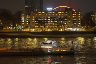 The Hyatt Regency Hotel on the Rhine, in Cologne Deutz, behind it the illuminated arch of the