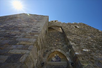 Medieval stone walls with a mosaic under a sunny sky, Agiou Theologou Monastery, St John's