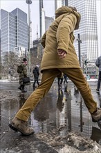 Winter in the city, Gallusanlage street, puddles, pools of water, melt water, pedestrians,