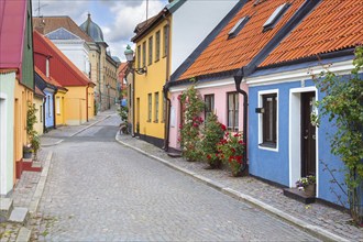 Cobbled street with colourful houses in pastel colours in the town Ystad in summer, Skåne, Scania,