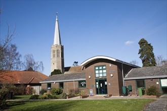 The octagonal tower of All Saints church, Wickham Market, Suffolk, England with public library and